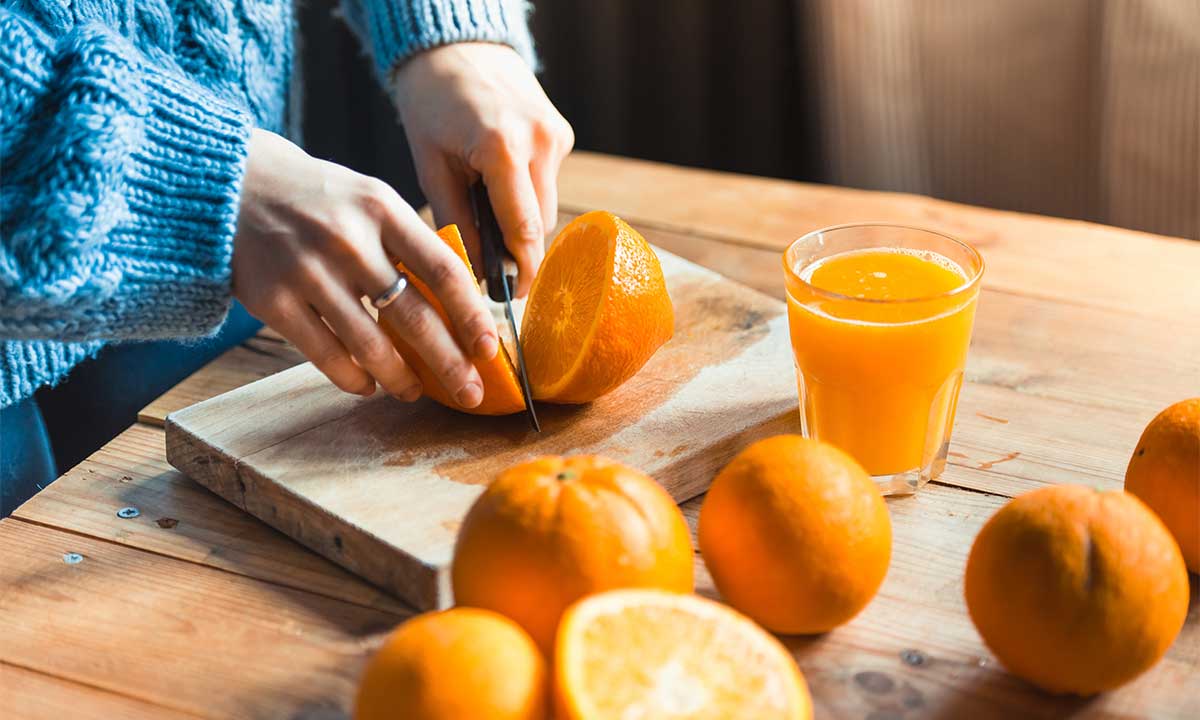 Frau schneidet Orangen auf