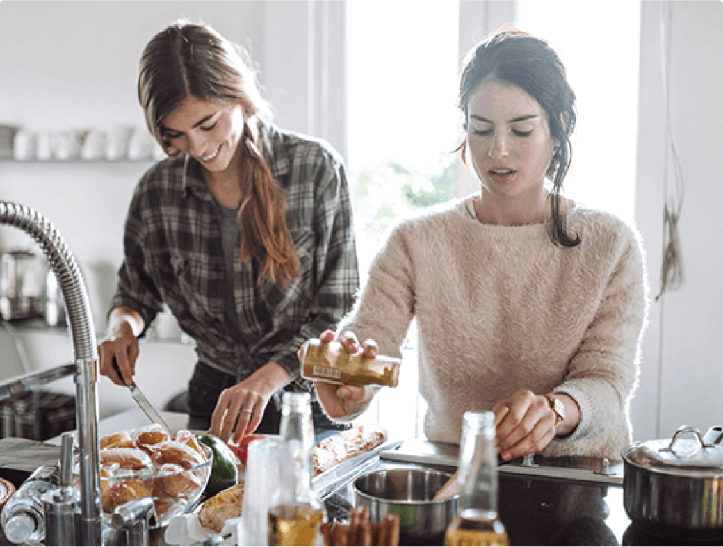 Zwei Frauen, die in der Küche stehen und gesund kochen