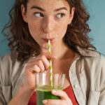 Frau trinkt grünen Smoothie