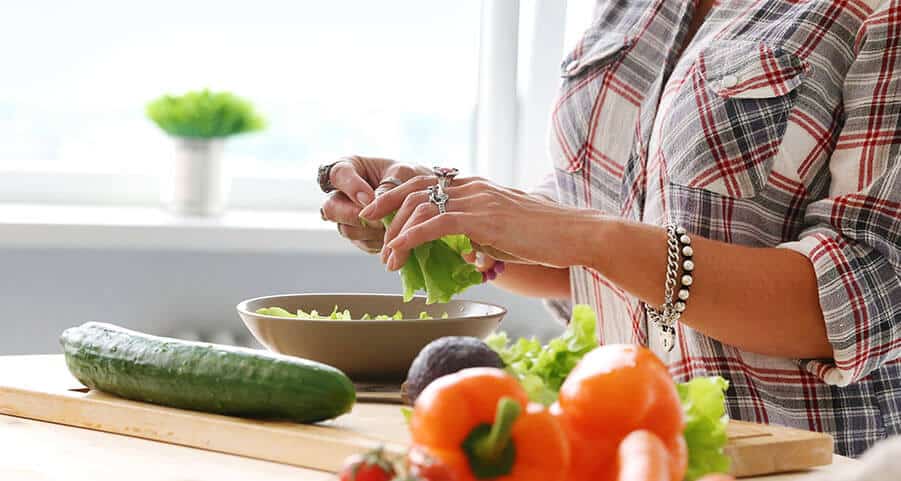 Frau bereitet Salat zu