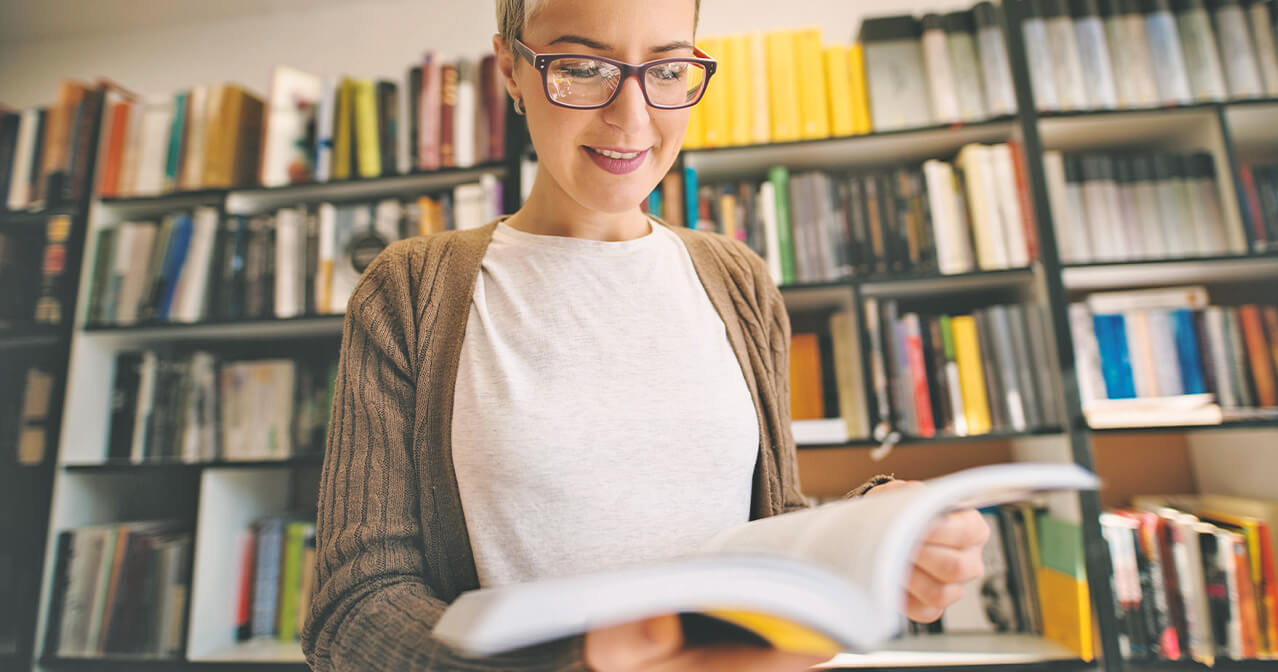 Frau, die in Fachzeitschriften und Büchern liest