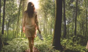Frau läuft barfuss im Wald