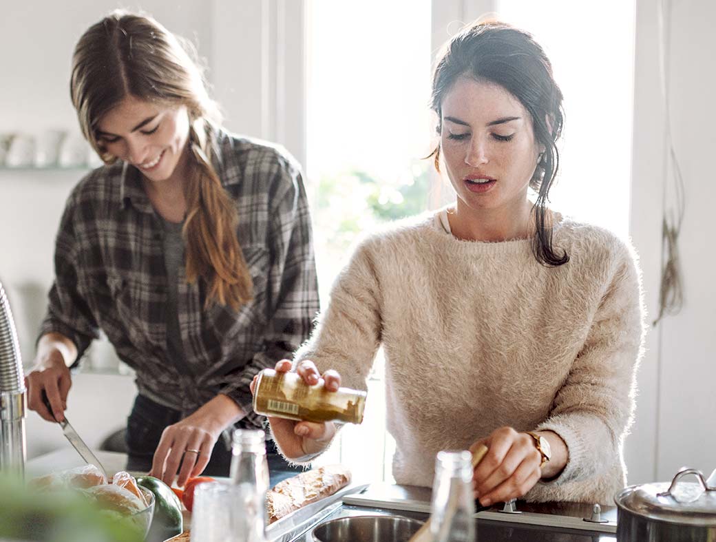 Zwei Frauen, die in der Küche stehen und gesund kochen