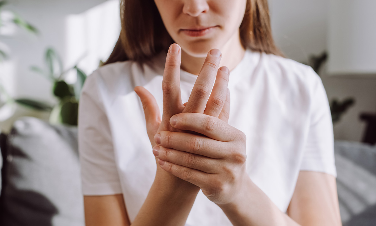 Frau hält sich die Hand