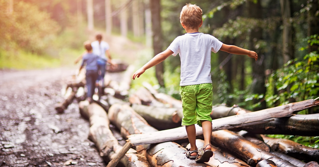 Kinder laufen auf Baumstamm – ganzheitliche Kindergesundheit