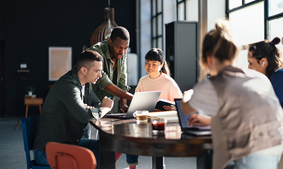 FOMO im Beruf: Personen arbeitet zusammen am Tisch