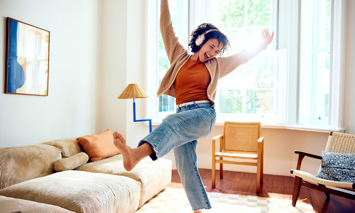 FOMO loswerden: Frau tanzt in der Wohnung
