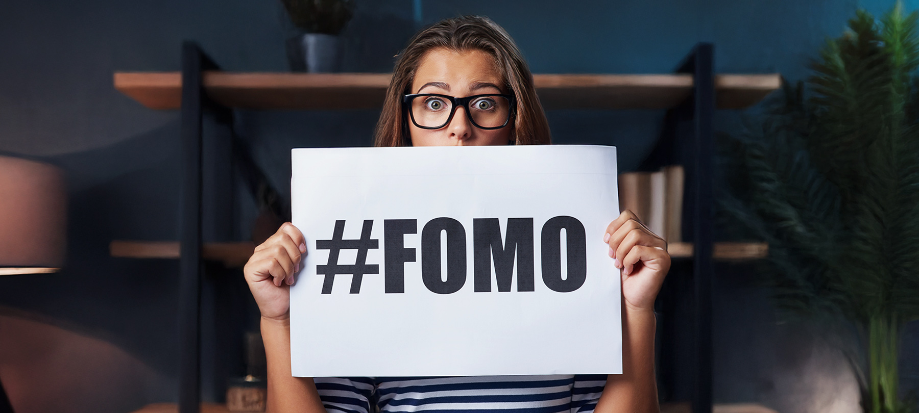 Frau mit FOMO-Schild in der Hand