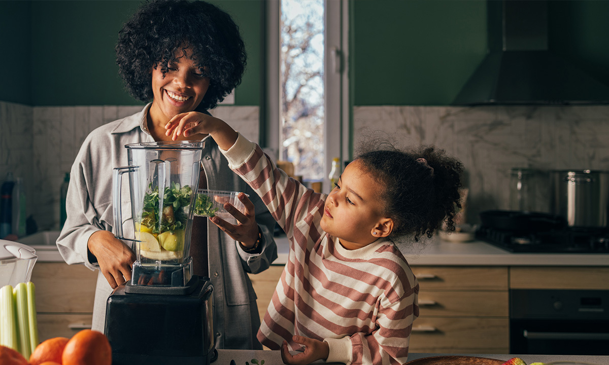 Mutter und Tochter kreiieren einen Smoothie mit vielen Vitaminen.