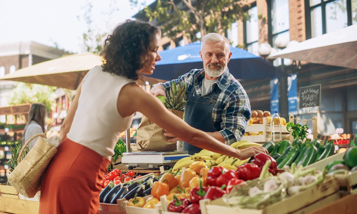 Frau kauft Gemüse auf einem regionalen Markt für eine natürliche, vitaminreiche Ernährung.